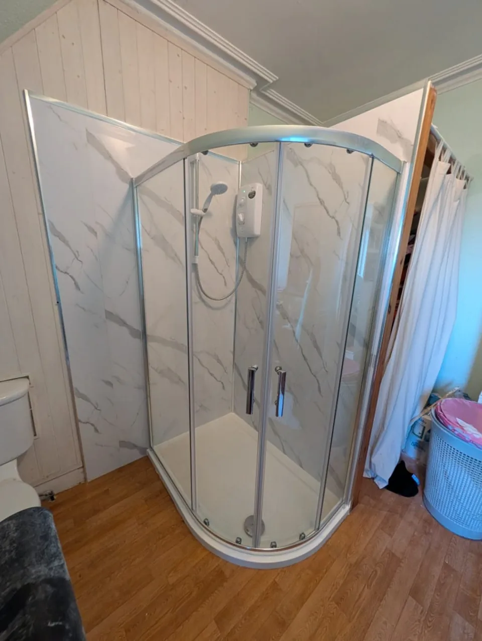 Curved shower enclosure with marble-effect wall panels