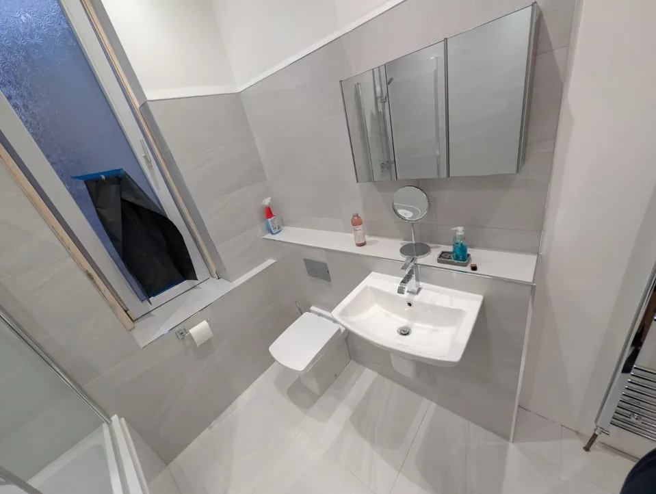Wall-mounted basin and mirror in a grey bathroom